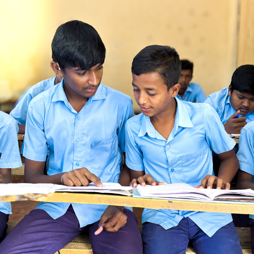 Two students helping each other read a text book